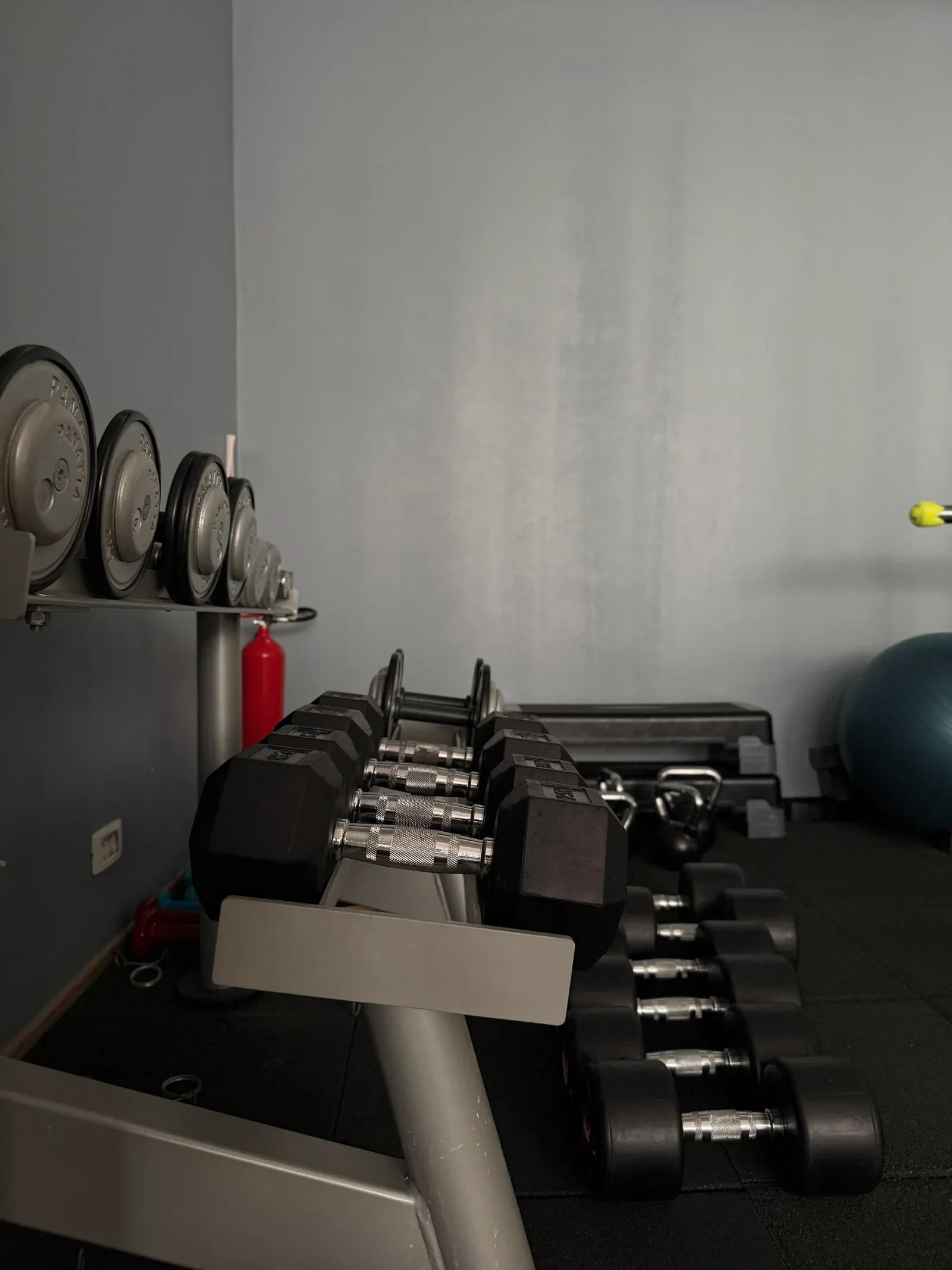 Gantere pe suport și kettlebell în zona cu pardoseală de cauciuc